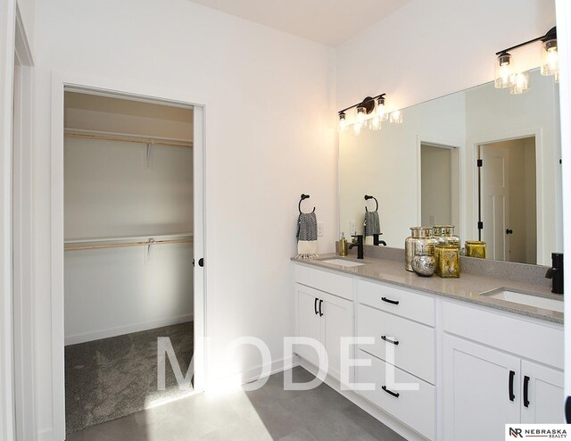 14803 Willow St, Bennington, NE 68007 - bathroom featuring double vanity, a spacious closet, and baseboards