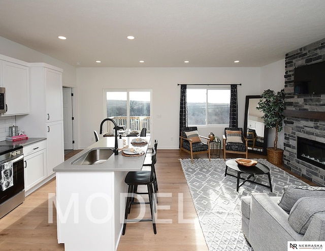 14803 Willow St, Bennington, NE 68007 - kitchen with a sink, appliances with stainless steel finishes, open floor plan, a breakfast bar, and light wood-style flooring