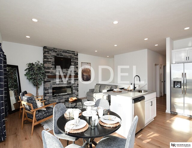 14803 Willow St, Bennington, NE 68007 - dining room with light wood-type flooring, recessed lighting, and a large fireplace
