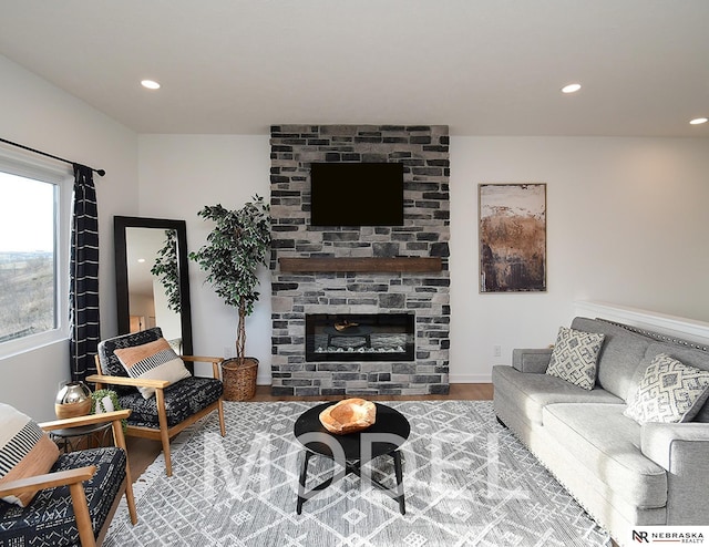14803 Willow St, Bennington, NE 68007 - living area featuring wood finished floors, recessed lighting, a stone fireplace, and baseboards