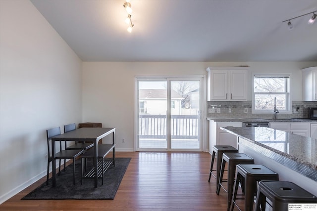 kitchen with white cabinetry, sink, backsplash, and light stone countertops