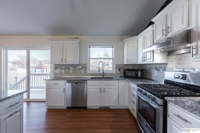 kitchen with sink, appliances with stainless steel finishes, dark hardwood / wood-style floors, light stone countertops, and white cabinets