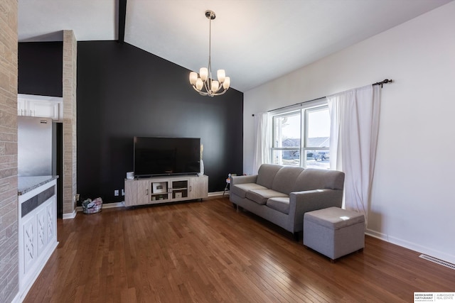 living room featuring dark wood-type flooring, lofted ceiling with beams, and a chandelier