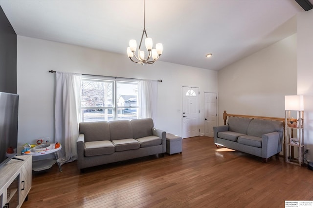 living room with lofted ceiling, dark hardwood / wood-style flooring, and an inviting chandelier