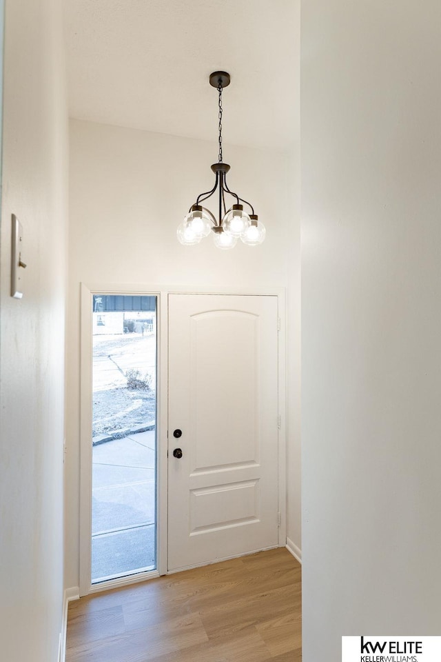 entryway with a chandelier and light wood-type flooring