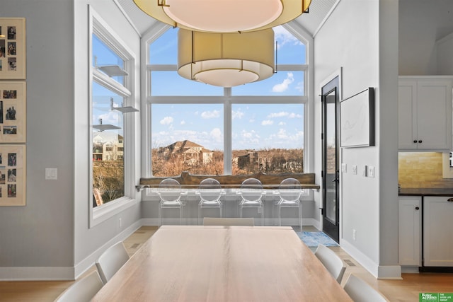 dining space featuring a high ceiling and light hardwood / wood-style flooring