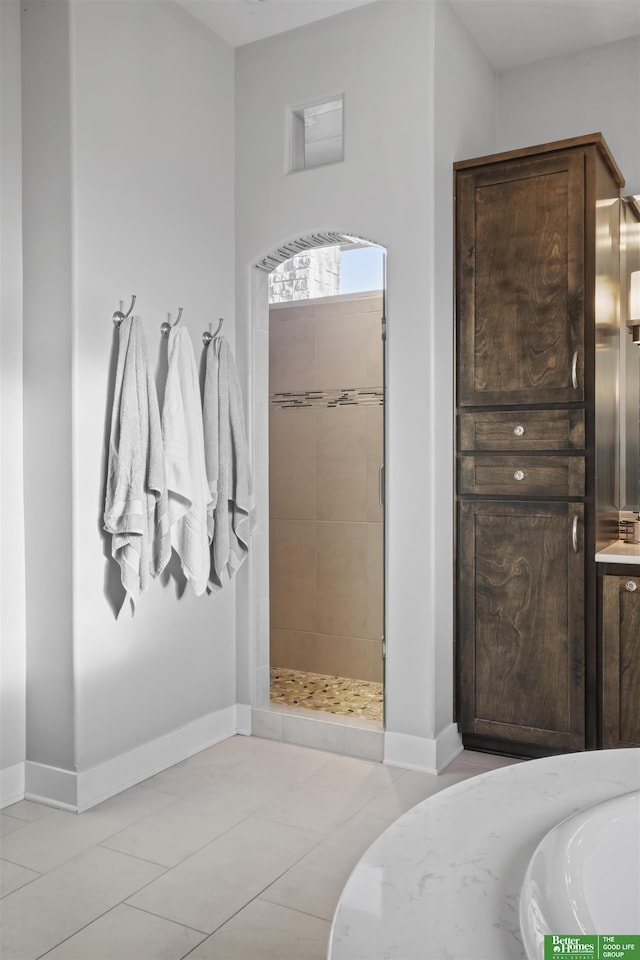 bathroom featuring tile patterned flooring and tiled shower