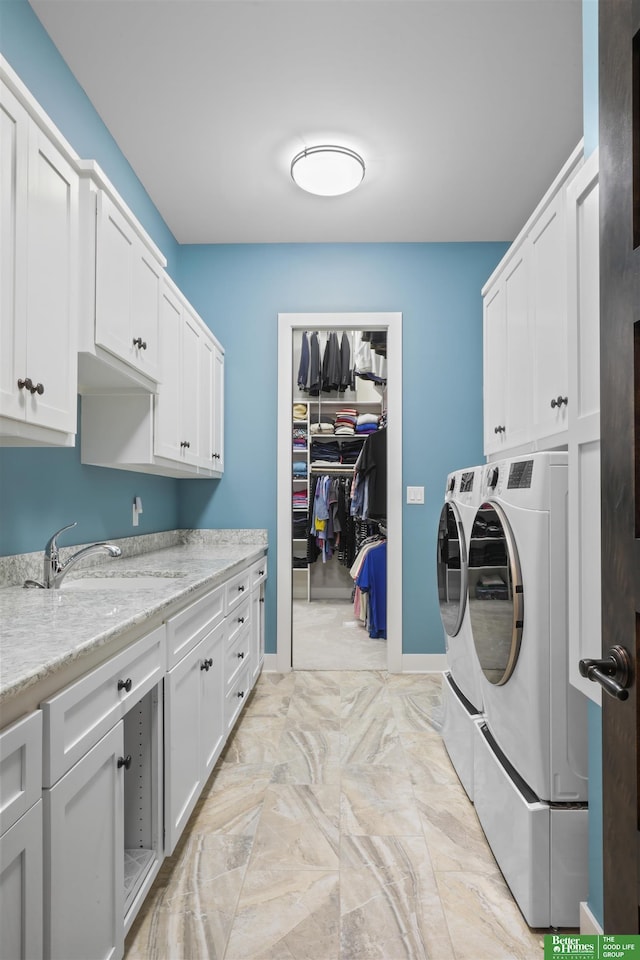 clothes washing area featuring cabinets, washer and dryer, and sink