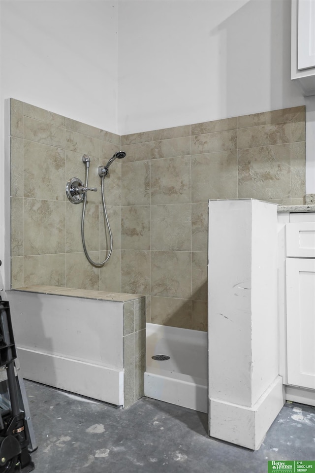 bathroom featuring tiled shower and concrete flooring