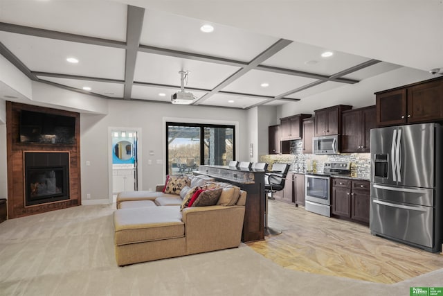 living room featuring beamed ceiling and coffered ceiling