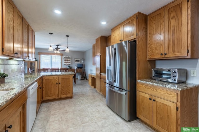 kitchen featuring pendant lighting, dishwasher, light stone countertops, stainless steel fridge with ice dispenser, and kitchen peninsula