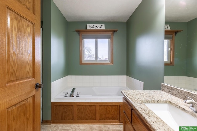 bathroom with vanity, a bathing tub, and a textured ceiling