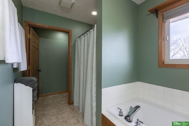 bathroom featuring a bath and a textured ceiling