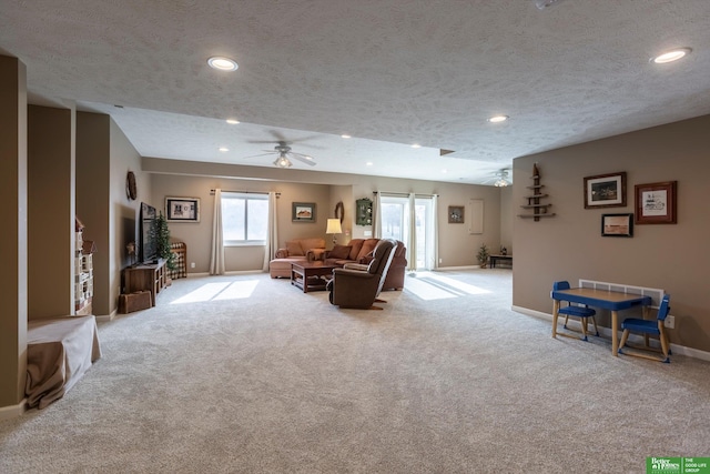 carpeted living room featuring ceiling fan, a barn door, and a textured ceiling