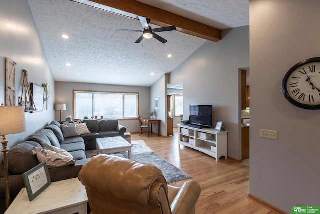 living room with ceiling fan, lofted ceiling with beams, a textured ceiling, and light wood-type flooring