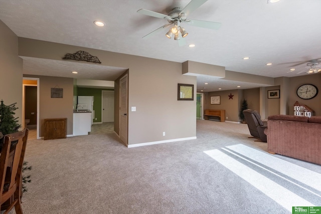 unfurnished living room with light carpet, a textured ceiling, and ceiling fan