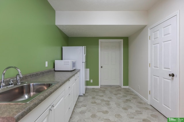 kitchen featuring sink and white cabinets