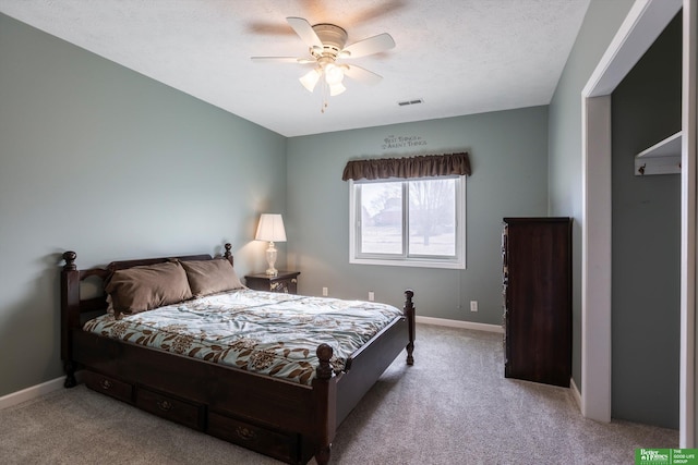 carpeted bedroom with a textured ceiling and ceiling fan