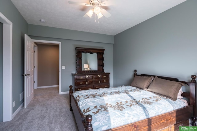 bedroom featuring a textured ceiling, light colored carpet, and ceiling fan