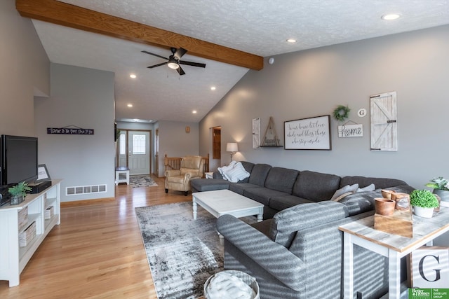 living room with lofted ceiling with beams, ceiling fan, and light wood-type flooring