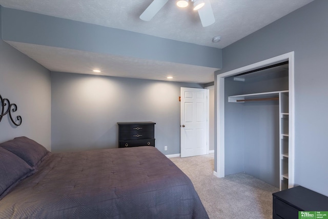 bedroom featuring light colored carpet, a textured ceiling, ceiling fan, and a closet