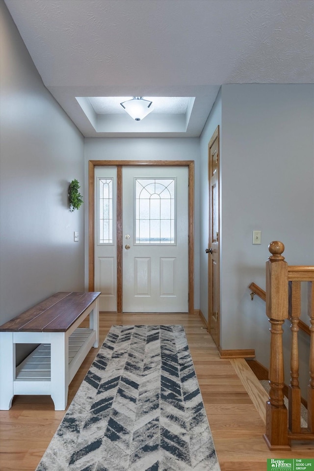 entryway featuring a tray ceiling and light hardwood / wood-style flooring