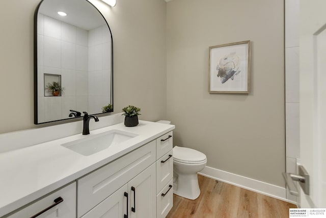 bathroom with vanity, toilet, and hardwood / wood-style floors