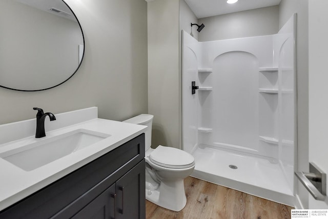 bathroom with vanity, hardwood / wood-style floors, a shower, and toilet