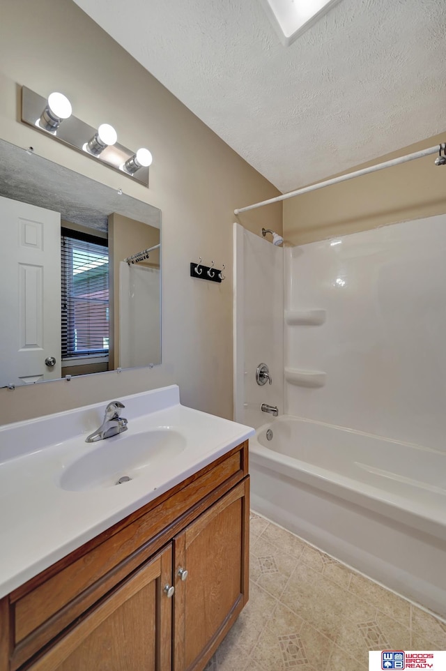 bathroom featuring vanity, a textured ceiling, and shower / bath combination