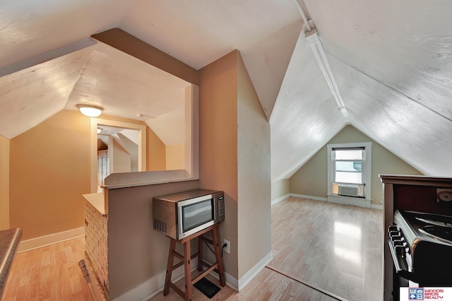 bonus room featuring cooling unit, vaulted ceiling, and light wood-type flooring