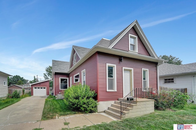 view of front of home with a garage, an outdoor structure, and a front yard