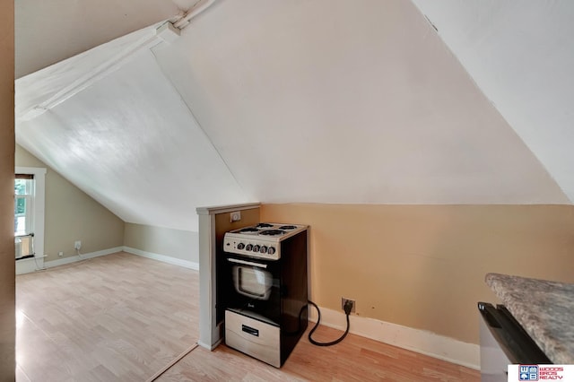 kitchen with lofted ceiling, light wood-type flooring, and electric range