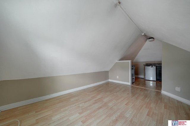 bonus room with vaulted ceiling and light hardwood / wood-style flooring