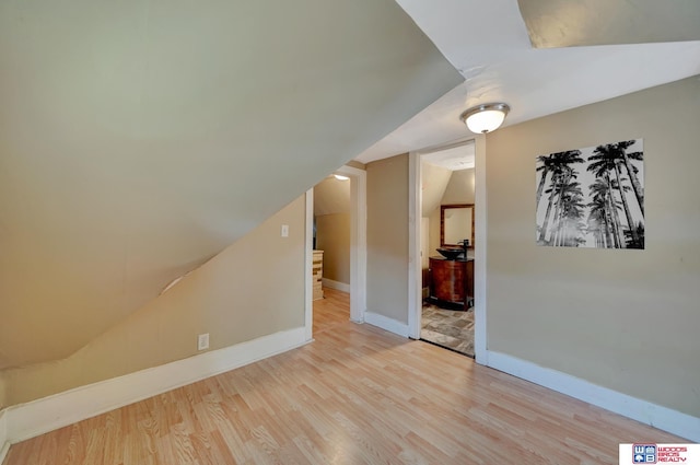 bonus room featuring lofted ceiling and light hardwood / wood-style flooring