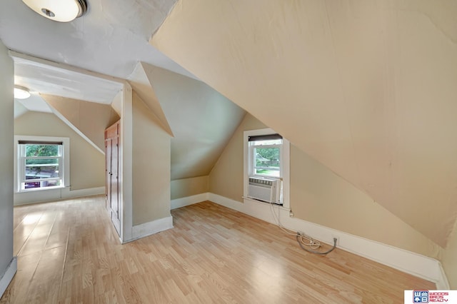 bonus room featuring cooling unit, lofted ceiling, a wealth of natural light, and light hardwood / wood-style flooring