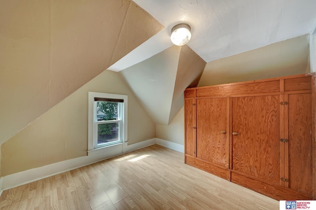 bonus room with vaulted ceiling and light hardwood / wood-style flooring