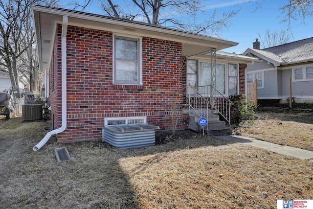 view of front facade featuring a front yard and central air condition unit