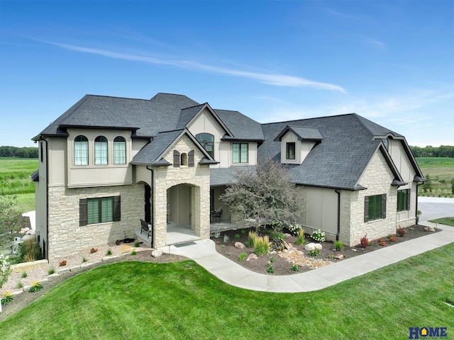 french provincial home with a front lawn