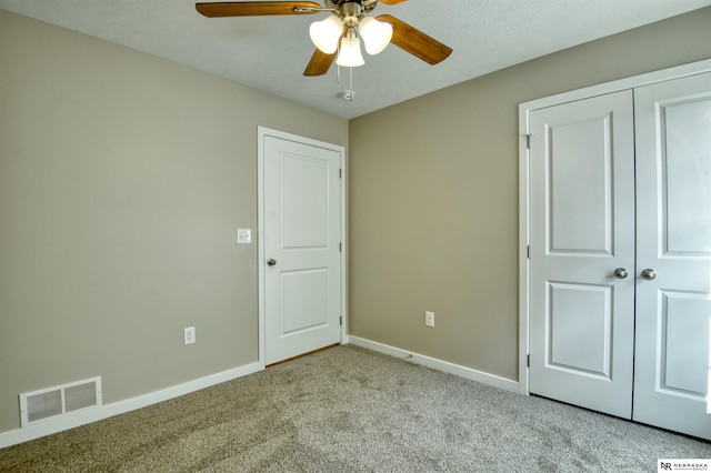 unfurnished bedroom with ceiling fan, a closet, and light carpet