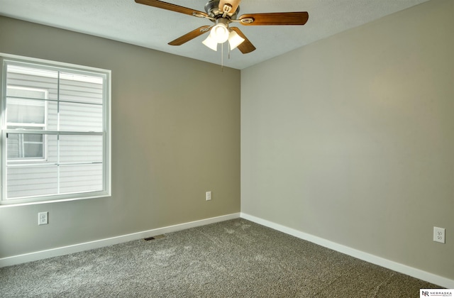 carpeted empty room with a wealth of natural light and ceiling fan