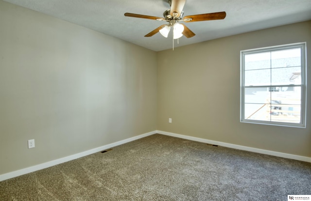 carpeted spare room featuring ceiling fan