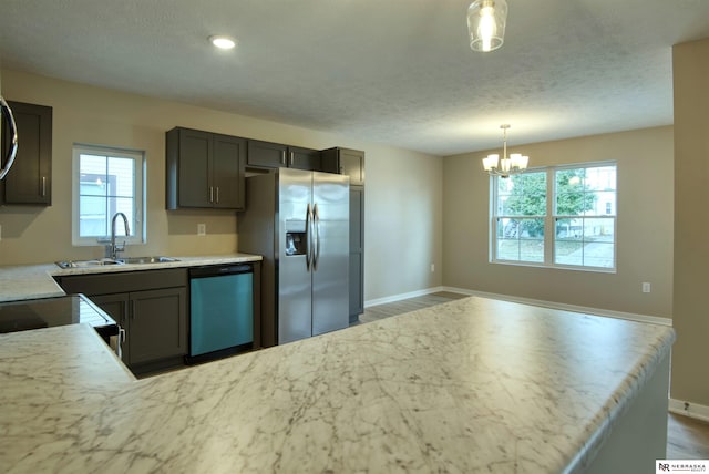 kitchen featuring dark hardwood / wood-style floors, appliances with stainless steel finishes, decorative light fixtures, and sink