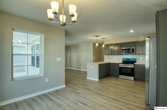 kitchen featuring stainless steel appliances, gray cabinetry, a notable chandelier, and decorative light fixtures