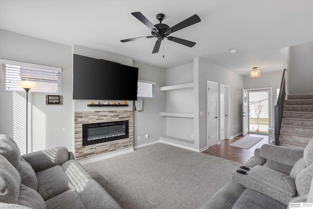 living room featuring a tiled fireplace, carpet, and ceiling fan