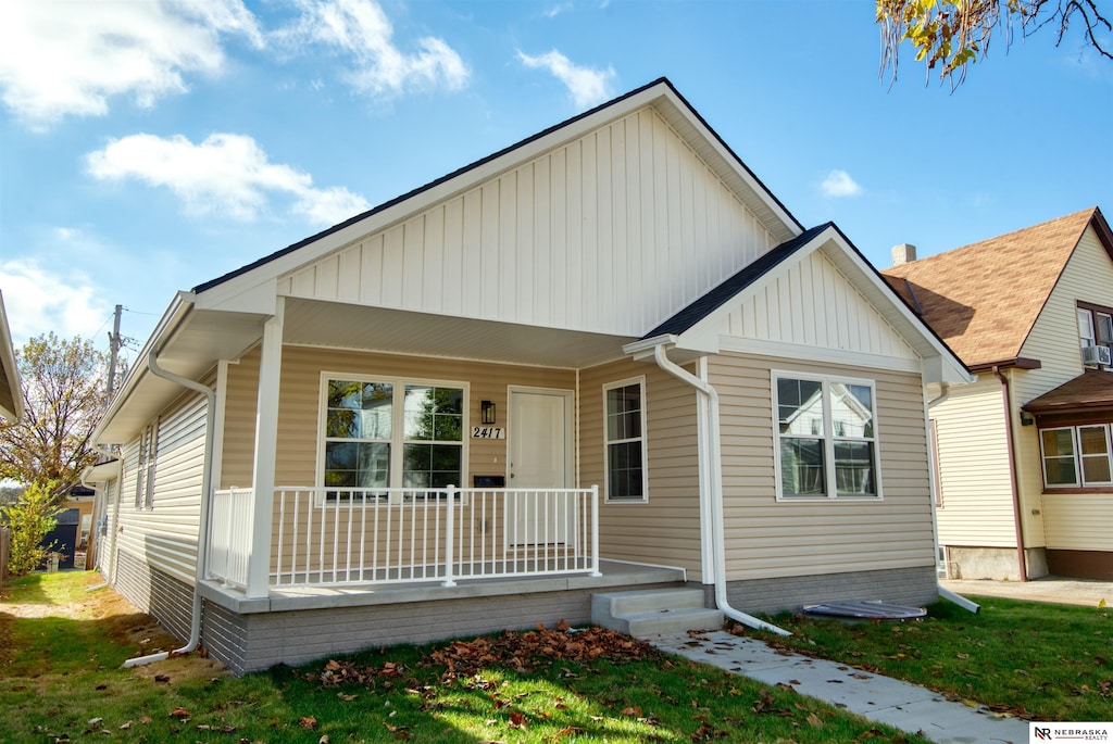 view of front of house featuring covered porch and a front lawn