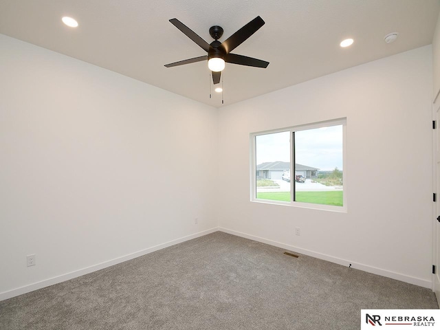 carpeted spare room featuring ceiling fan