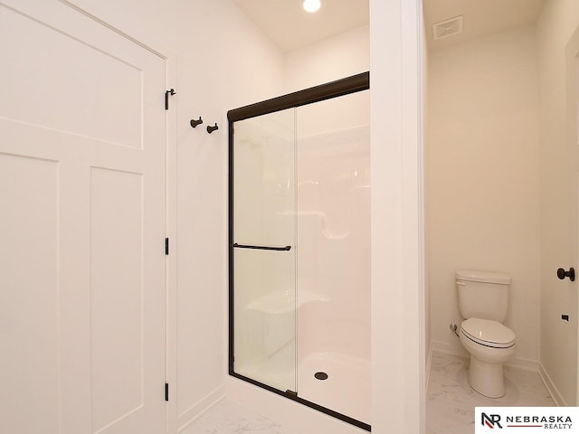 bathroom featuring toilet and an enclosed shower