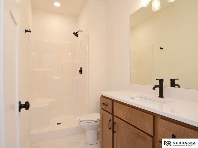 bathroom with vanity, toilet, and a shower