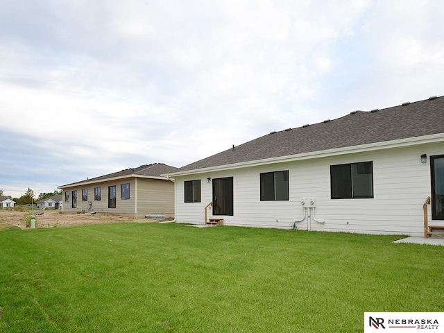 rear view of house featuring a yard