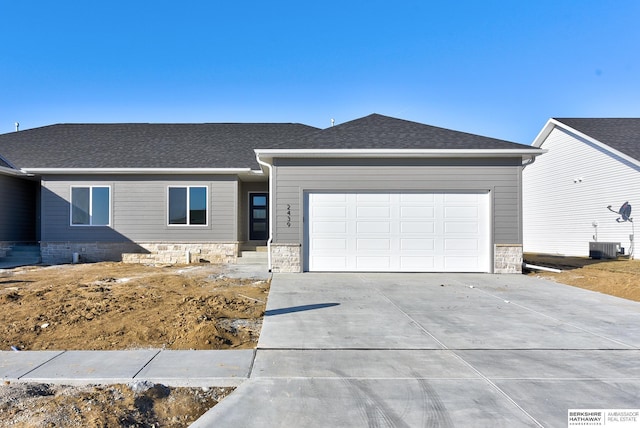 view of front of property with a garage and central air condition unit